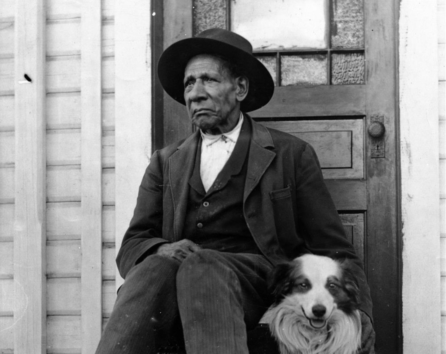 George Washington is pictured with his dog on a porch in this photograph from the Washington State Historical Society.